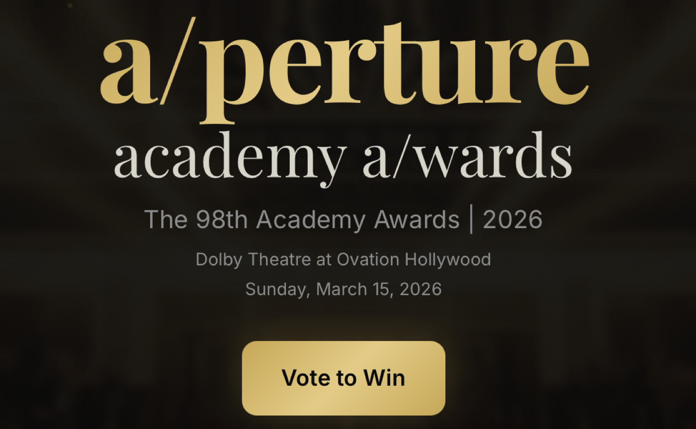 The a/perture academy a/wards ballot: gold serif wordmark over a darkened theatre, with a Vote to Win button